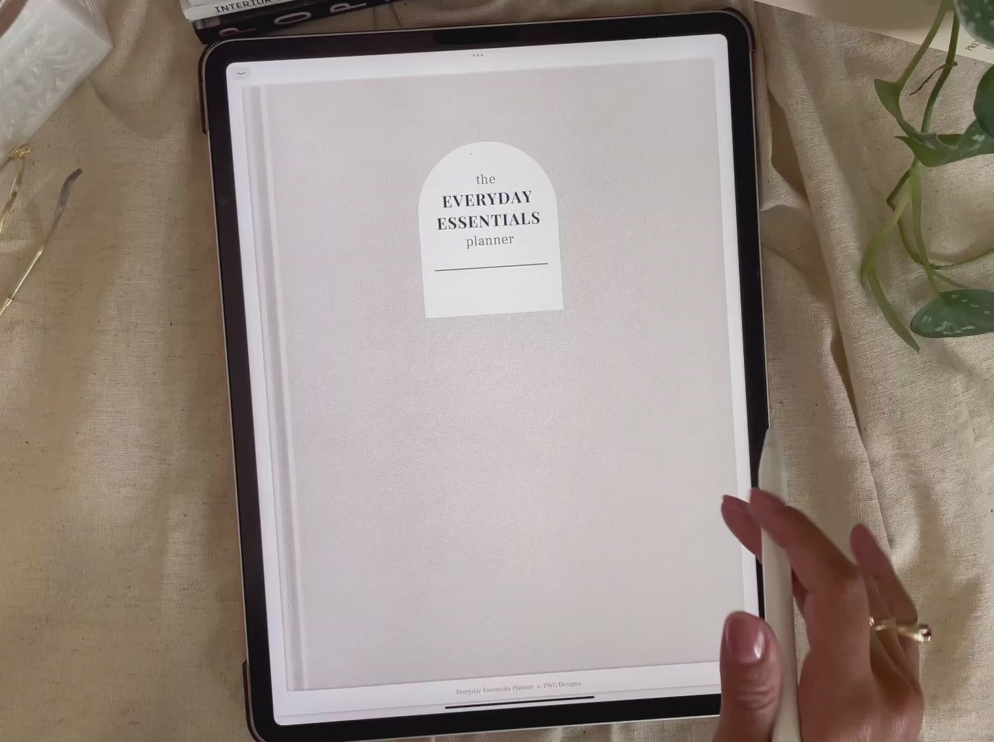 Planner cover with minimalist neutral tones displayed on iPad, stylus hovering over screen.